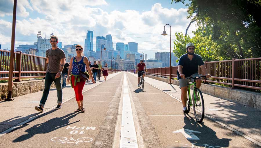 View of people walking and biking across the Stone Arch Bridge