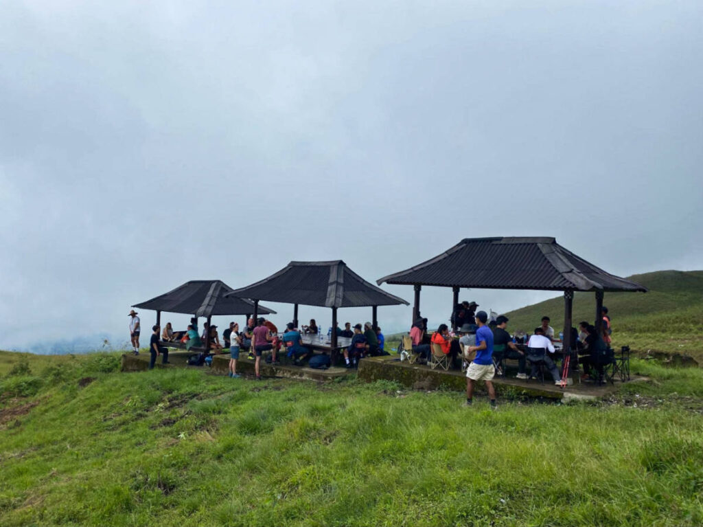 Group of hikers eating in the small huts
