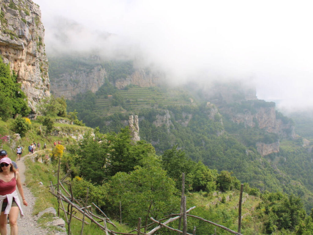 People hiking up a mountain path on the trail of Path of the Gods