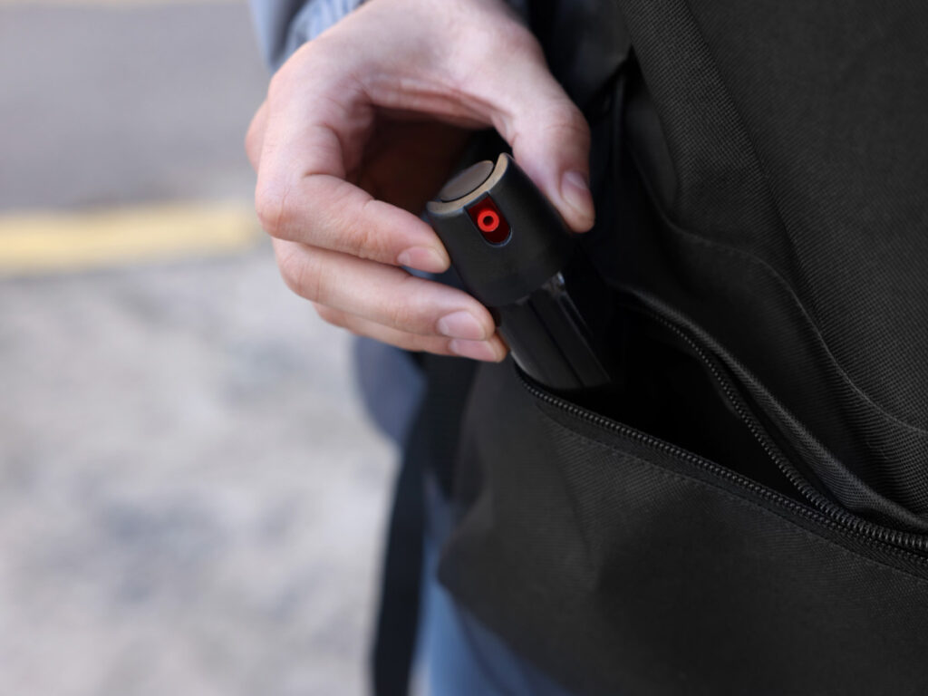 A hand getting a pepper spray on the bag