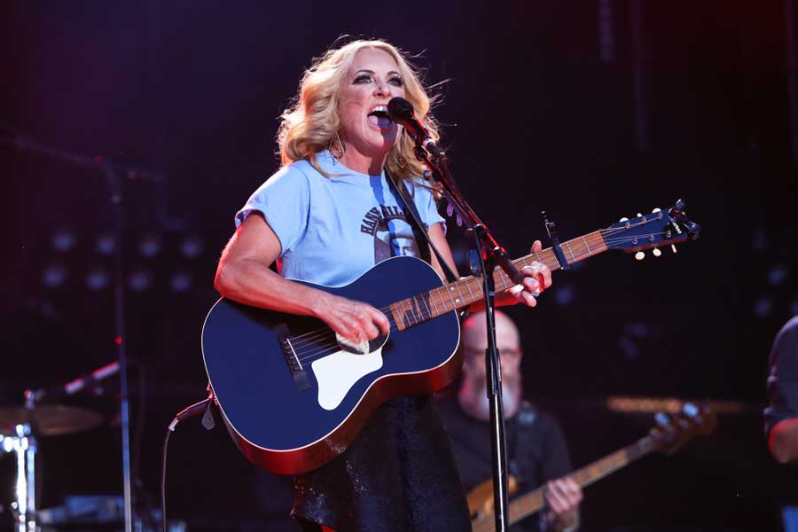 A woman performing with her guitar in CMA Fest