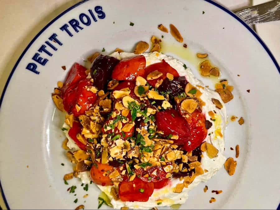 Seasoned tomatoes and fresh burrata in a Petit Trois plate
