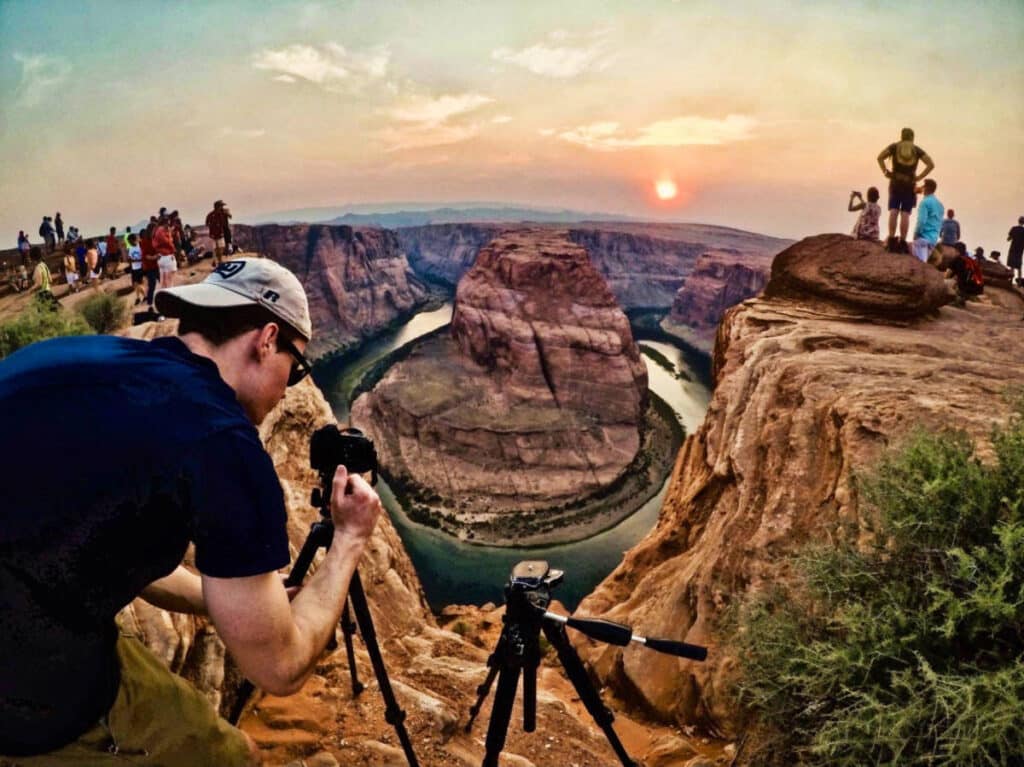 The author Betty Hurd's brother, taking a photo with the crowd at the Horseshoe Bend at sunset