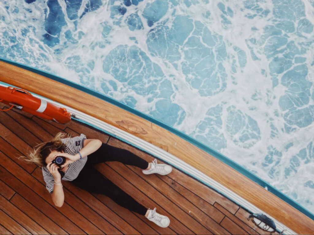 A woman with a camera on a cruise ship deck seen from above