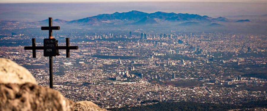 Aerial view of Mexico City from Ajusco mountain range with a cross in the foreground