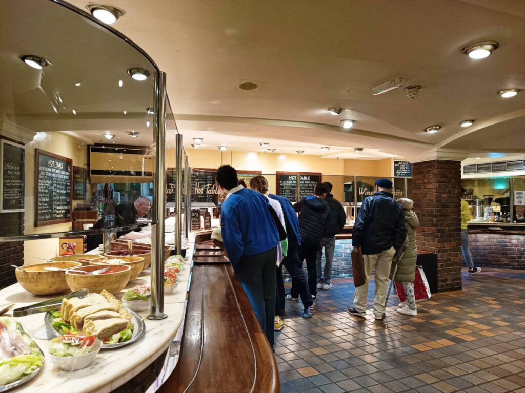 View of the people looking at the displayed foods on the counter at Pillars Restaurant