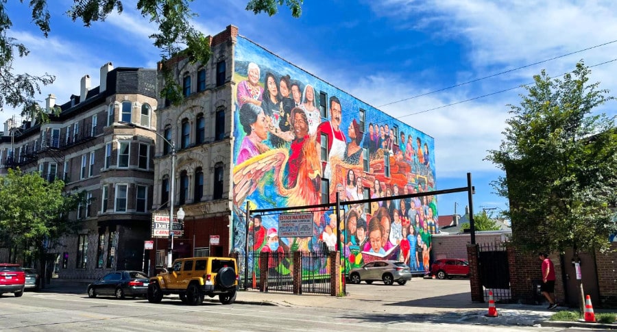 A tall wall covered with vibrant and colorful murals in Downtown Pilsen