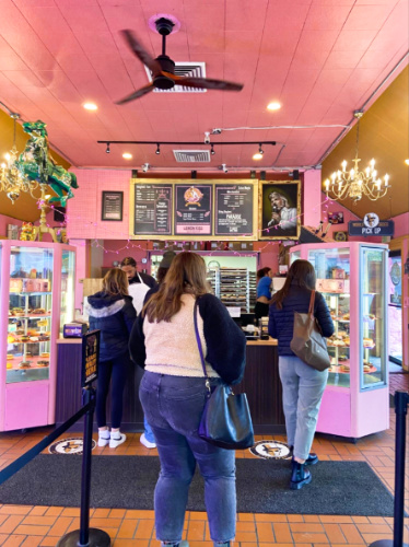 People lining up at the counter of the beautiful interior of Voodoo Doughnut