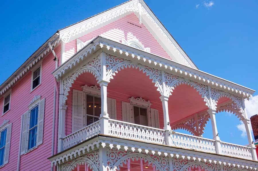 A pink Victorian style house from the outside under the clear blue sky in Cape May