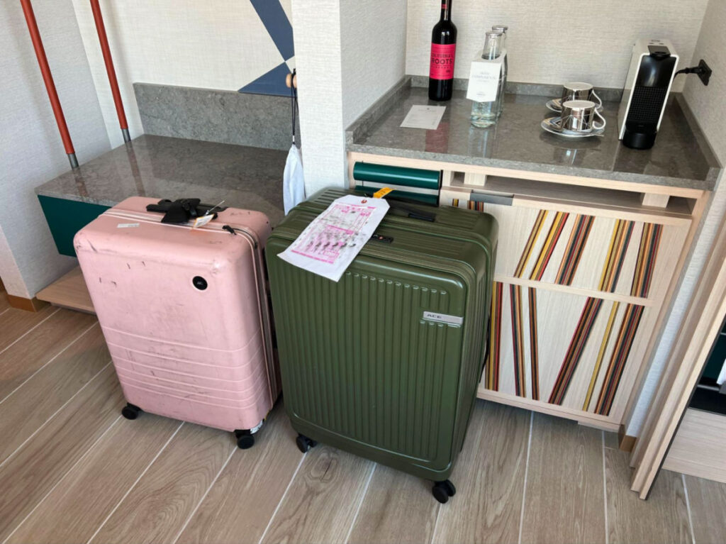 Pink and green baggage at a hotel room