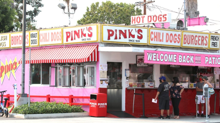 Exterior view of the iconic pink gourmet hotdog restaurant of Pink’s Hotdogs