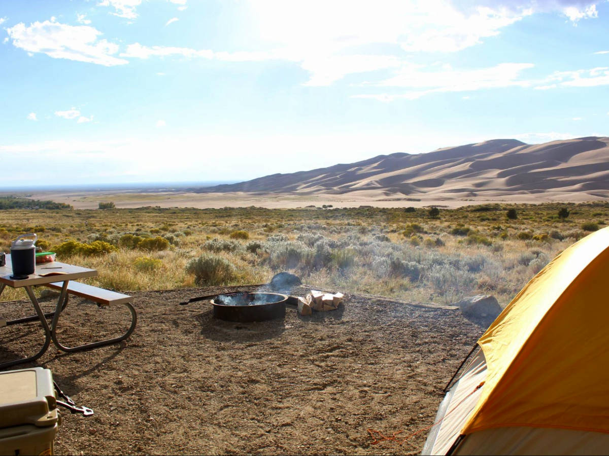 A fire pit, table and a tent at the Piñon Flats Campground