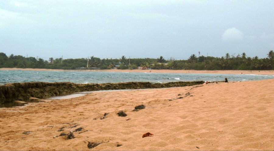 View of sand by the sea in Piñones