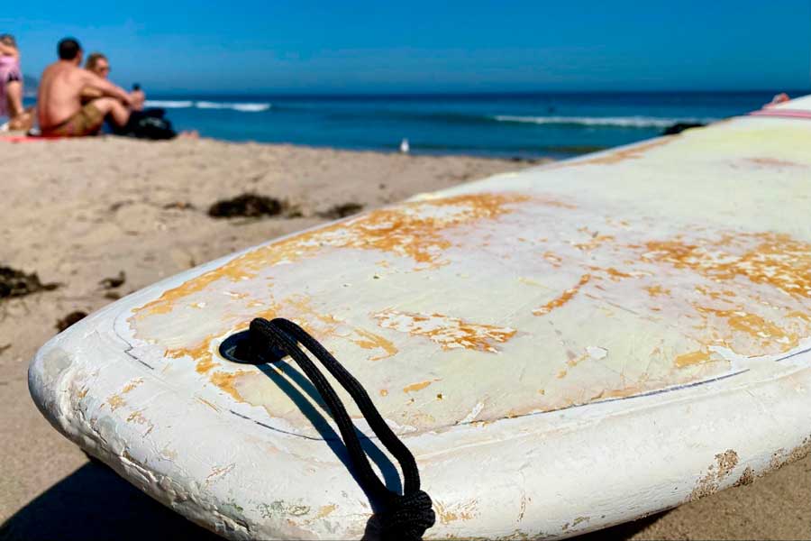 A surfboard on a sand in Pismo Beach