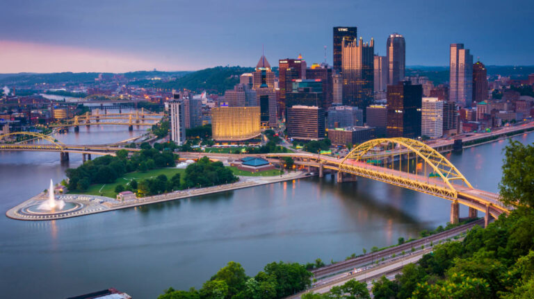 Aerial view of a bridge and buildings in Pittsburgh at night