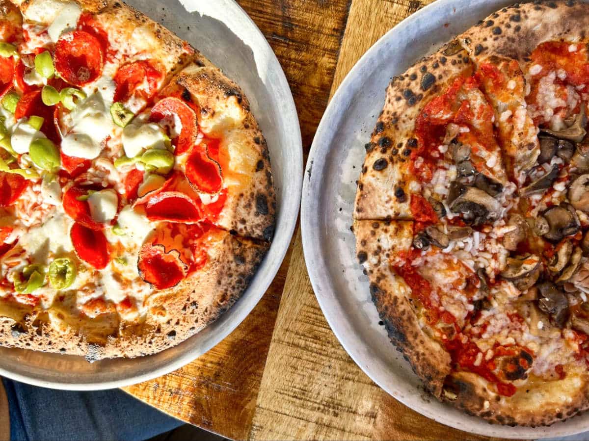 Closeup view of the two variety of pizza from Crosscut Pizzeria and Taphouse