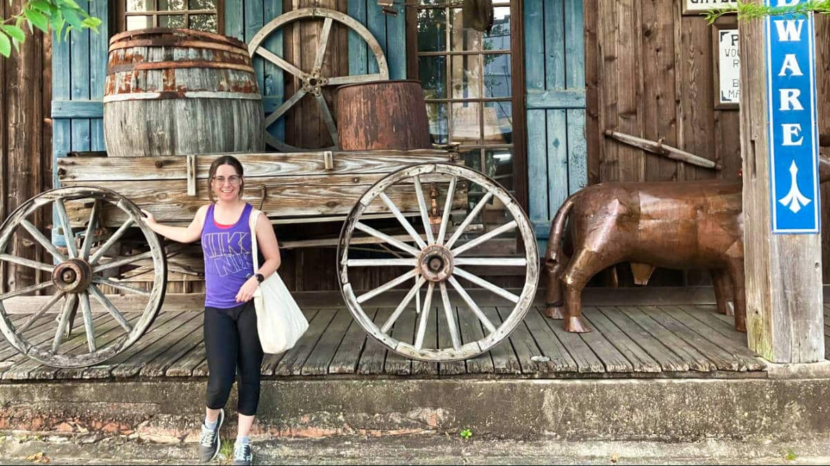 The author Meg O'Connor, posing with a carriage and a statue on one of the best places to live in Louisiana