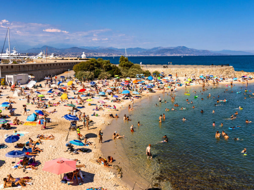 View of the people enjoying the sunny day at the white sand Plage de la Gravette