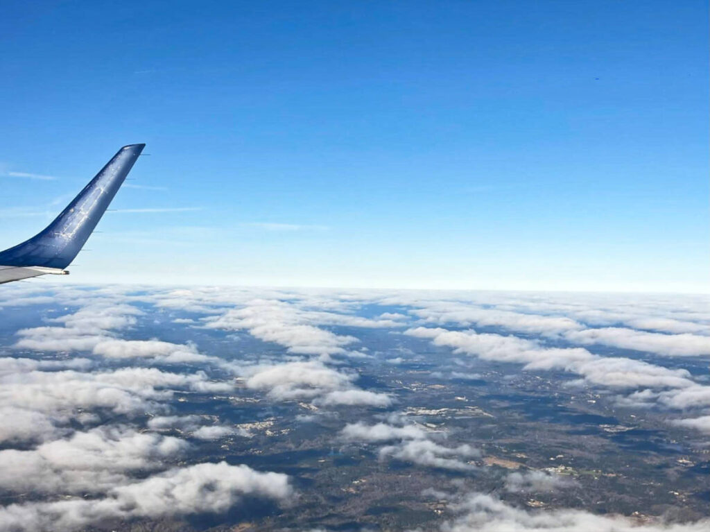 View of the plane's wing and the cloudy sky from the window seat