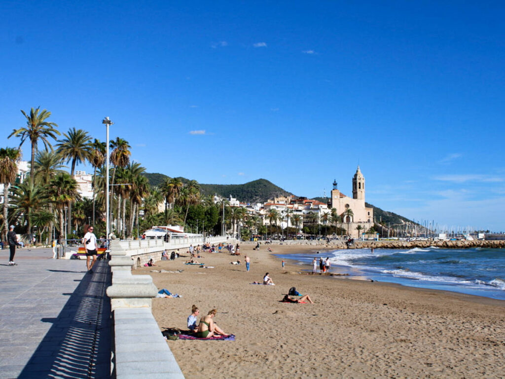 View of the people chilling along the shoreline at Platja de Sitges