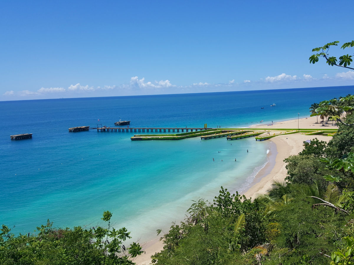 A scenic view of Playa Crash Boat, featuring a pier extending into the ocean