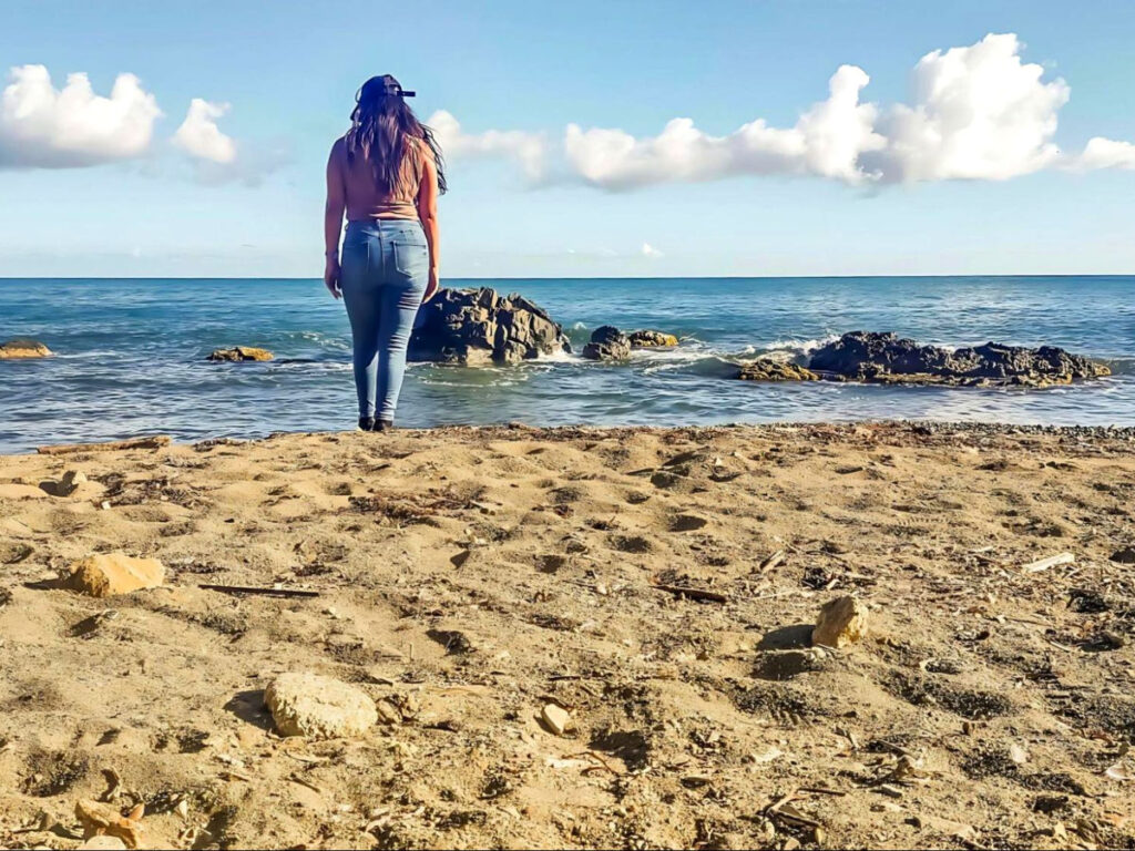 Author Vanessa Ramos standing at Playa La Fanduca, staring at the ocean
