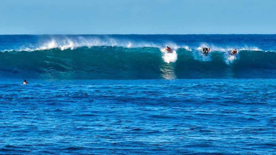Surfers riding the wave in Playa Los Tubos
