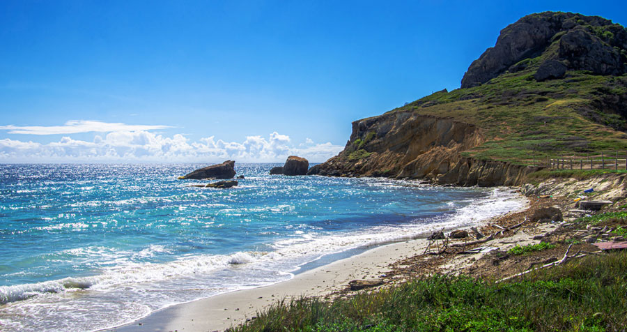 View of Playa Pelicano and a rugged hill in Caja de Muerto