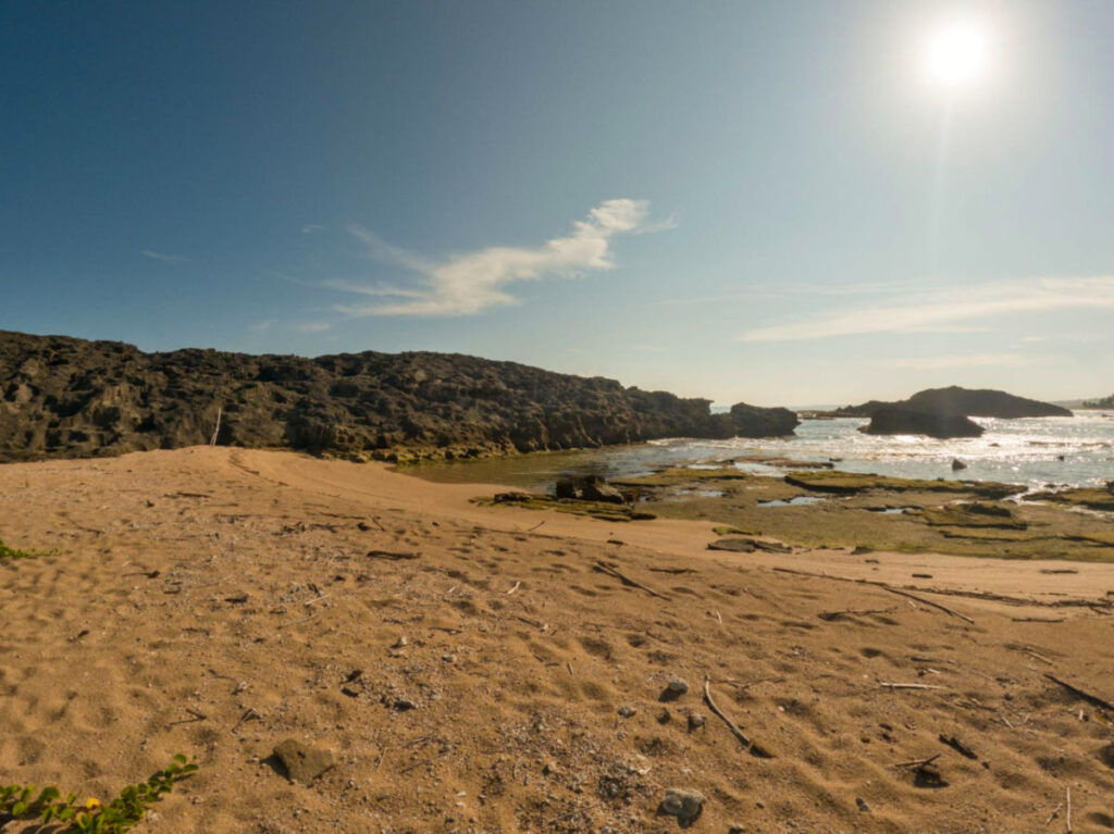 View of Playa Tómbolo featuring a sandy beach and rocky formations along the shore
