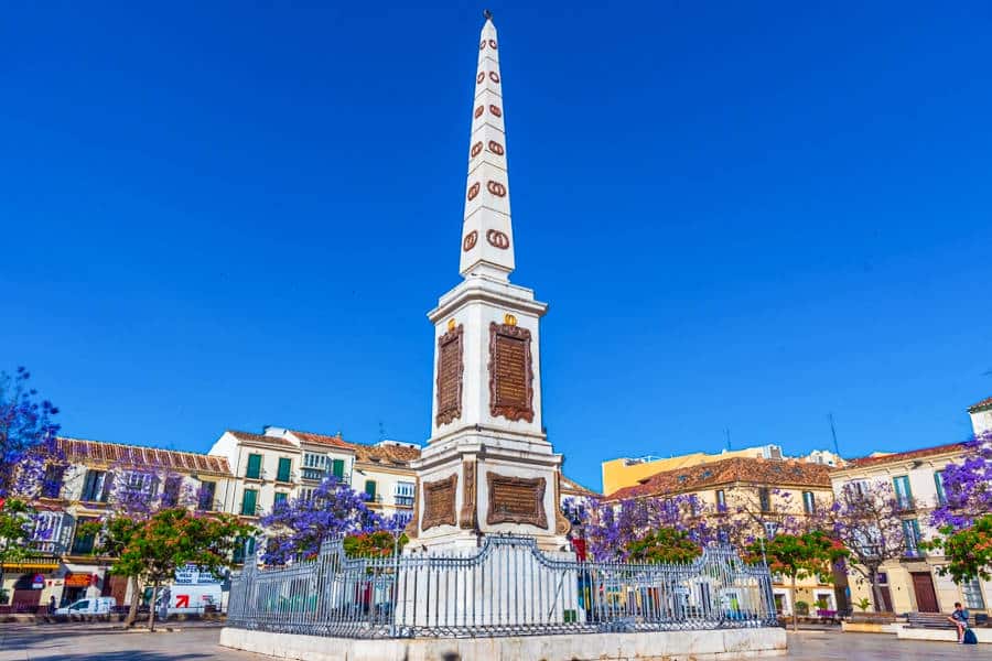 View of the tall monument at Plaza de la Merced with a clear blue sky in the background