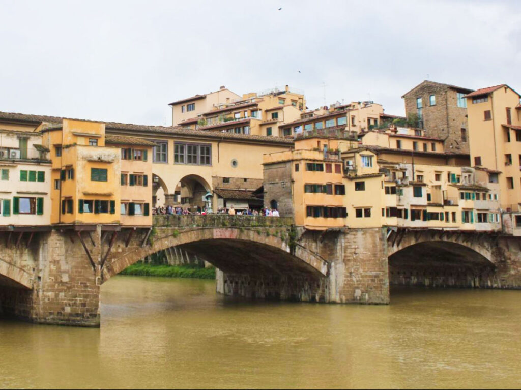 View of the crowd at the Ponte Vecchio bridge seen from across the river