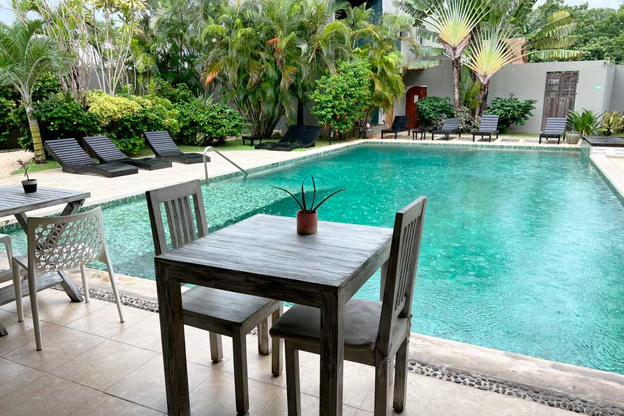 View of a table and chairs with a pool view in Villas H20