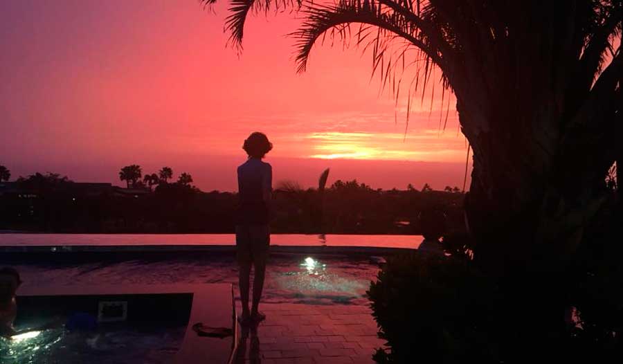 View from the pool area of a vacation rental during sunset