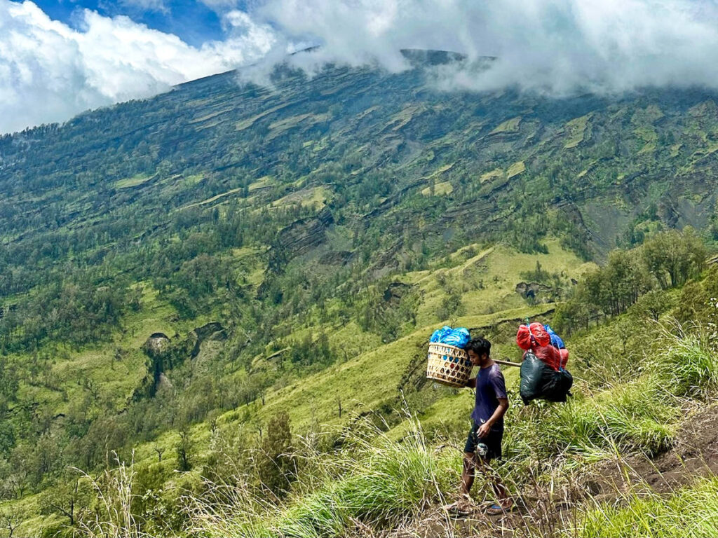 A porter hiking down the mountain carrying the gears