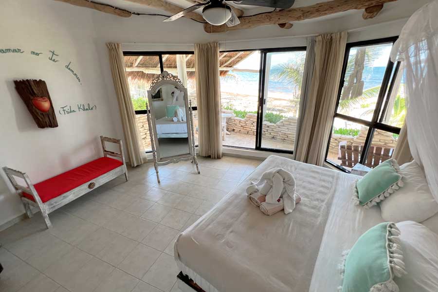 View from the inside of a bedroom with a beach view in Posada Punta Piedra