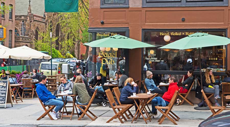 People enjoying their coffee on an outdoor dining area in New York City