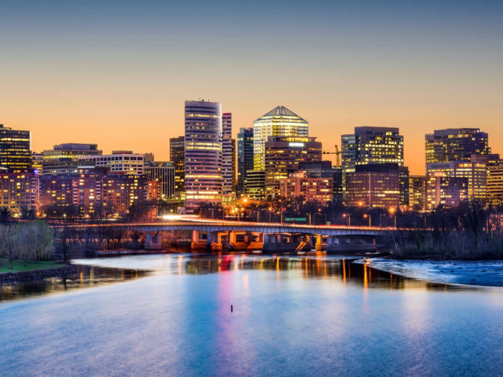 Buildings in Arlington with lights before night time across the Potomac River