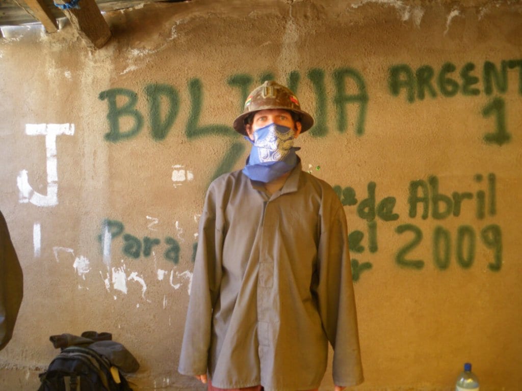 A miner standing in front of a wall with graffiti