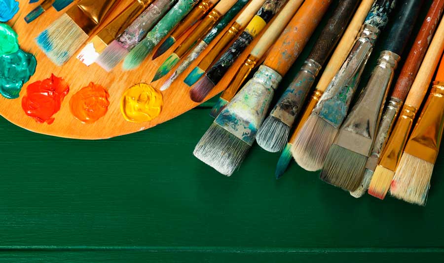 Paint brushes and different color of paint on a palette