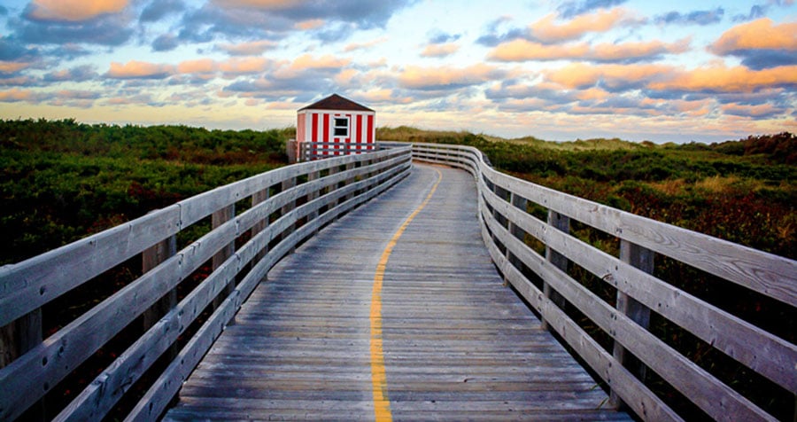View of a boardwalk in Prince Edward Island and the colorful sky during sunset
