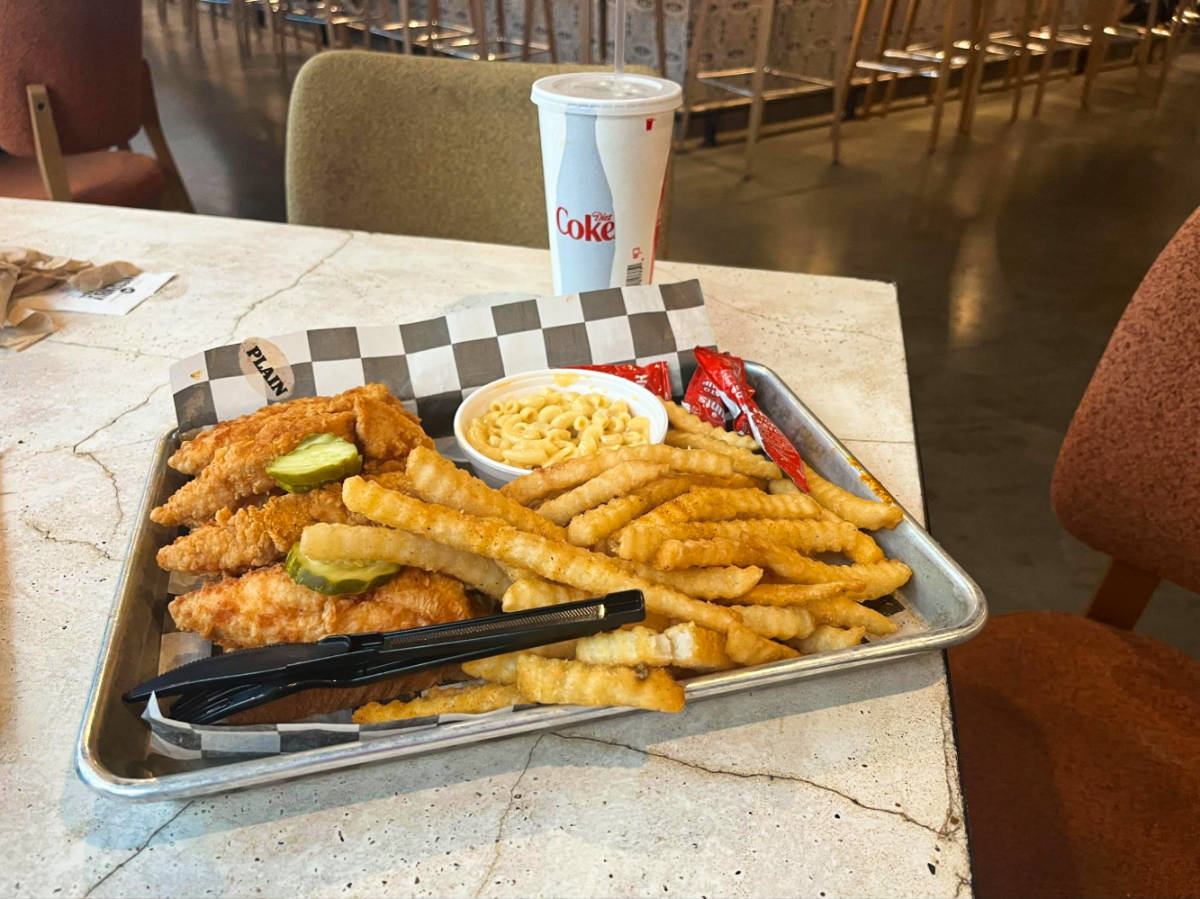 A food try full of fried chicken, fries with a dip and a cup of Coke on the side