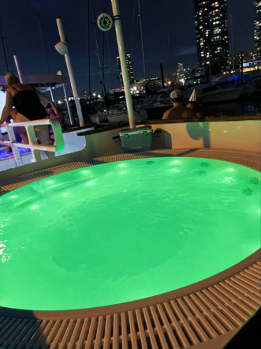 The private hot tub illuminated at night on the boat tour
