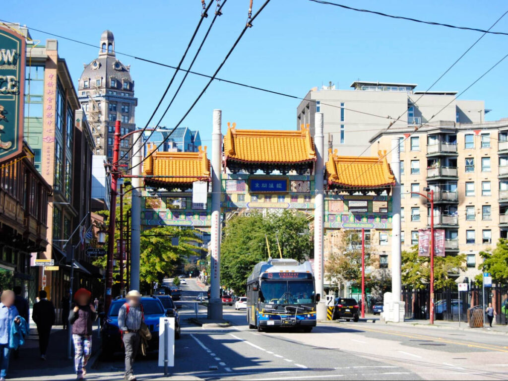 A public bus passing under the Millenium Gate at the Chinatown in Vancouver
