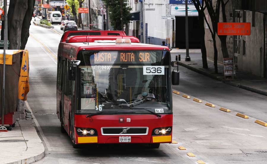 View of a red bus travelling on the street of Mexico City