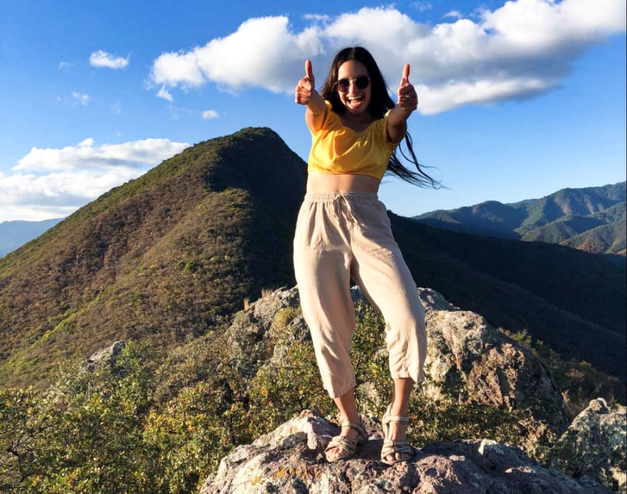 The author McKenna Mobley posing at the summit of Pueblos Mancomunados in Oaxaca