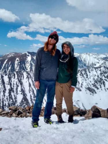 Abigail Bliss with her husband smiling for a photo at the summit of Quandary Peak
