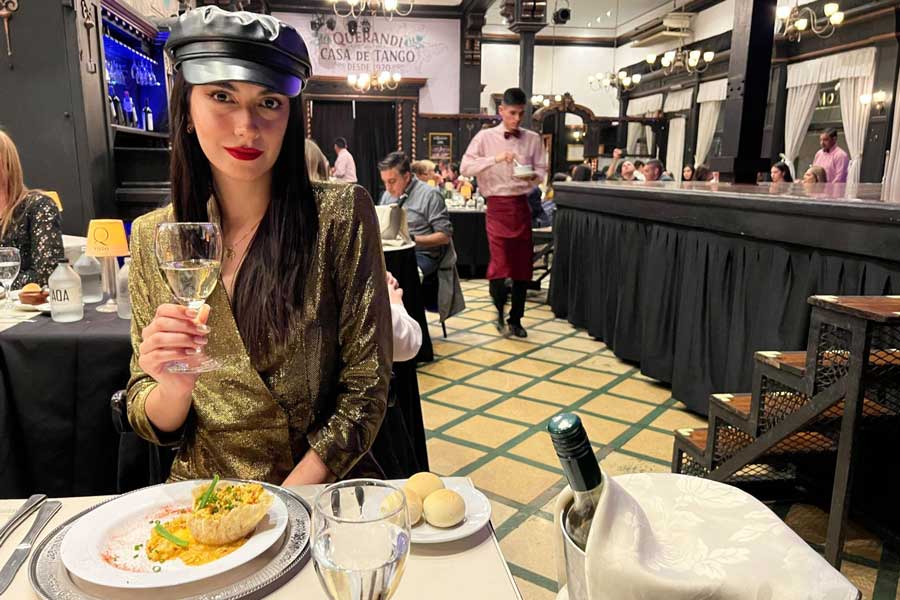 Clara holding a glass of white wine in Querandí Casa de Tango