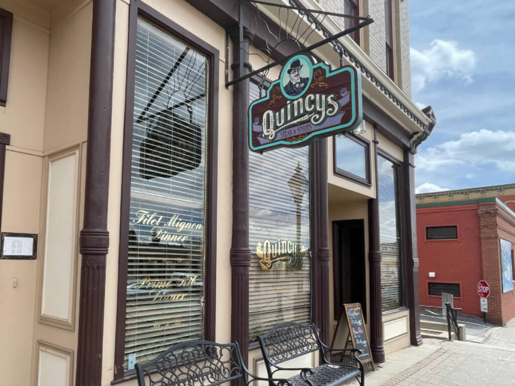 View of the signage and exterior of Quincys Steak & Spirits