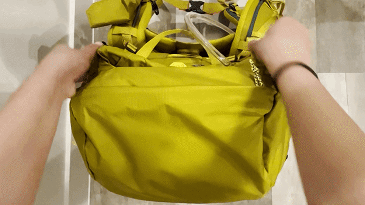 A demonstration of removing the lid of REI Co-Op Flash 55 Backpack