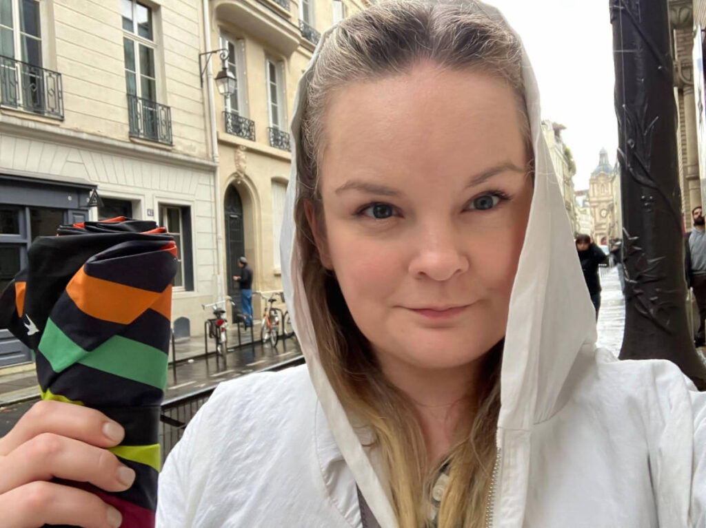 The author, Rachel Kapelke-Dale smiling for a selfie while holding an umbrella